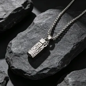 Vintage aromatherapy essential oil diffuser necklace with hollow rectangular pendant on rocks