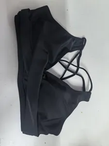 Vista dettagliata del top bikini nero incrociato con davanti arricciato e spalline incrociate