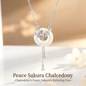 Primer plano de collar de plata S925 con colgante de mariposa y flor de cerezo en calcedonia