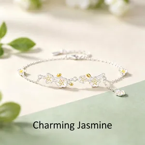 Detalle de una pulsera de plata s925 con flores de jazmín blancas y toques dorados
