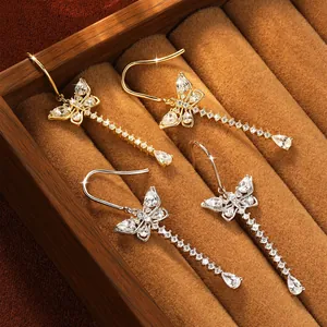 Elegant butterfly tassel earrings with sparkling moissanite stones in a jewelry box.