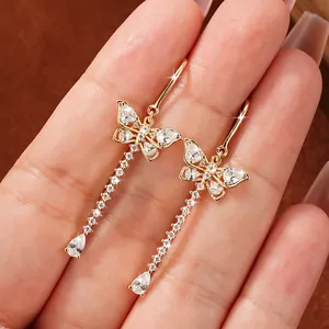 Detailed close-up of sparkling butterfly tassel earrings in gold-tone finish