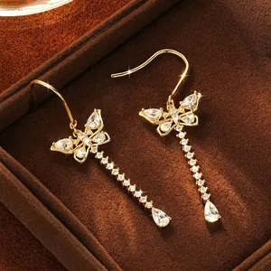 Sweet gold butterfly tassel earrings with sparkling moissanite stones in a velvet box.