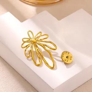 Detailed view of an abstract golden sunflower brooch on a minimalist white display stand