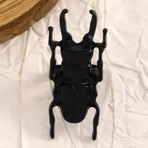 Vista dettagliata di un orecchino creativo a forma di scarabeo nero opaco stile