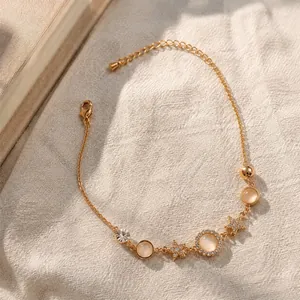 Goudkleurige armband met kattenoogstenen en delicate sterrenhangers.