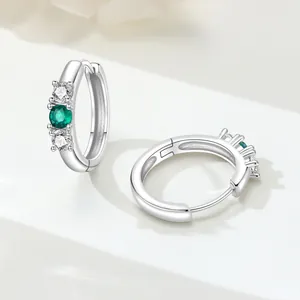 Vista dettagliata di orecchini a cerchio in argento 925 con zirconi verde smeraldo e chiari