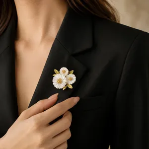 Close-up of elegant white daisy brooch with golden leaves pinned on a black blazer