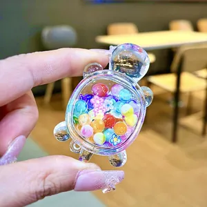 Macro detail of a transparent acrylic turtle ornament filled with colorful sand beads