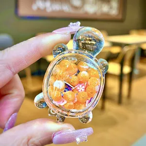 Close-up of a mini transparent acrylic turtle ornament filled with orange decorative beans