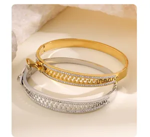 Gros plan de bracelets en acier titane en forme de fermeture éclair dorés et argentés