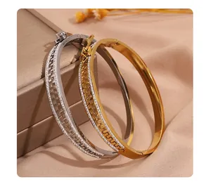 Détail de bracelets en acier inoxydable doré et argenté avec design fermeture éclair.