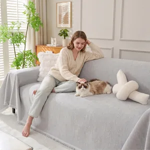 Scène de salon confortable avec une housse de canapé en chenille grise à franges