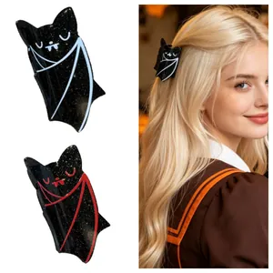 Detail of glittery black bat hair claws in white and red outlines worn by a model.