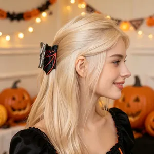 Close-up of a black and red glitter bat hair claw clip worn by a model