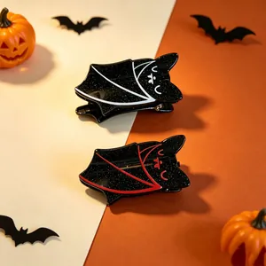 Detailed macro view of black glitter bat hair clips with white and red outlines.