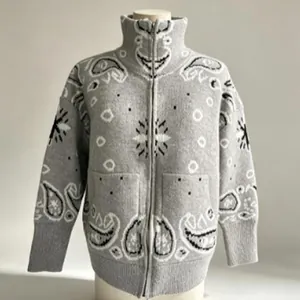 Detail of vintage grey knitted cardigan with black paisley pattern and front zipper.