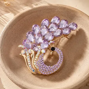 Elegante spilla a pavone placcata in oro con cristalli viola sfaccettati e strass