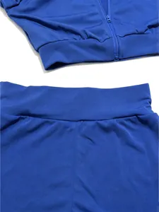 Dettaglio completo sportivo blu reale con cerniera e vita elastica su sfondo bianco