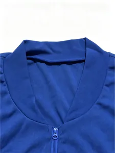 Dettaglio macro della giacca sportiva blu reale con cerniera e colletto alla coreana.
