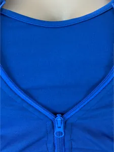 Dettaglio ravvicinato della cerniera blu e del tessuto a costine di un top sportivo