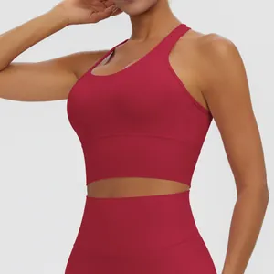 Vue détaillée d'un soutien-gorge de sport rouge avec dos nageur et bande large pour le yoga.