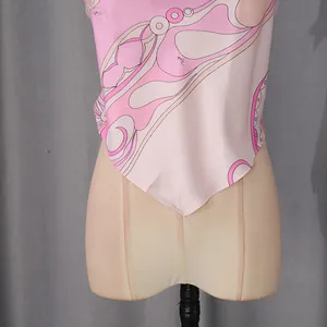 Detail view of pink printed sleeveless halter top with V-shaped hem and silky texture