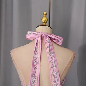 Close-up detail of pink resort style halter top featuring a back bow tie and geometric print