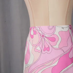 Close-up of the vibrant pink and white psychedelic floral print on the skirt fabric.