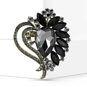 Detail of elegant heart-shaped brooch featuring faceted black and smoky gray crystals