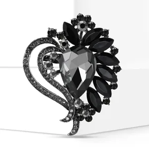 Detail close-up of a heart-shaped brooch with faceted black glass stones and crystals