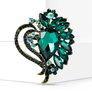 Detailed view of an elegant heart-shaped brooch with green crystals