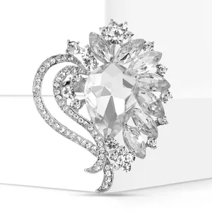 Macro view of elegant heart-shaped brooch set with faceted clear crystals on a silver base