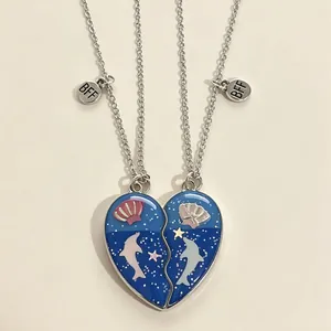 Détail du collier cœur magnétique avec motifs dauphin bleu océan et breloques BFF