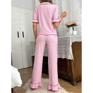 Rückansicht eines rosa zweiteiligen Pyjama-Sets mit Rüschenbesatz und Stoff
