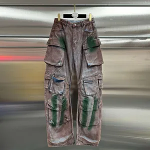 Washed brown cargo jeans with multiple pockets and green spray paint details