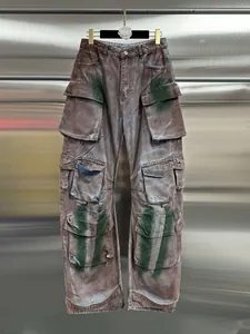 Vintage washed brown multi-pocket cargo jeans with industrial green spray-paint details