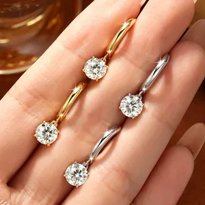 Primo piano di orecchini moissanite colore D a quattro griffe in finitura oro e argento