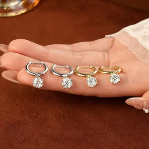 Dettaglio ravvicinato di quattro orecchini a cerchio in moissanite su una mano.