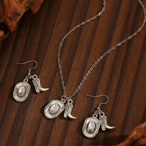 Vintage Western cowboy jewelry set featuring silver boot and hat pendants on wood