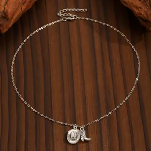 Close-up of retro silver cowboy hat and boot charms on a delicate Western style chain.