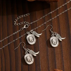 Detailed view of silver western cowboy hat and boot pendants on a wooden surface