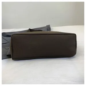 Detailansicht des stabilen rechteckigen Bodens einer dunkelbraunen minimalistischen Stofftasche.