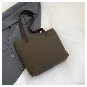 Detailansicht der braunen Canvas-Tragetasche und ihrer stabilen Schultergurte.