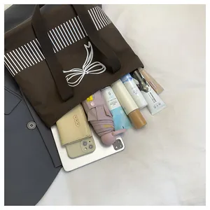 Detailansicht der großen Kapazität der braunen Canvas-Tasche mit Schleife