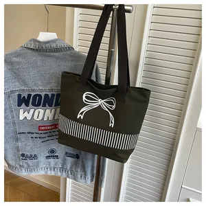 Detailansicht der dunkelgrünen Canvas-Tasche mit weißem Schleifen- und Streifendruck