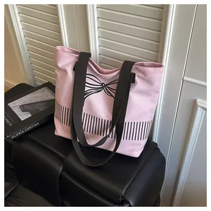 Seitenansicht einer rosa Canvas-Tragetasche mit schwarzer Schleife und Streifendesign