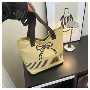 Minimalistische gelbe Canvas-Schultertasche mit schwarzem Schleifenprint und Streifen