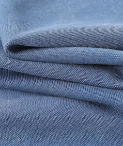 Detailopname van 300g gewassen blauwe katoenen stof met retro distressed textuur