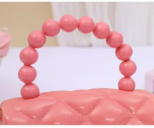 Detailansicht einer rosa gesteppten Mini-Geleetasche mit stilvollem Perlengriff oben
